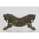 Chinese carved dark green hardstone pillow in the form of two back-to-back kylin, 27cm long.