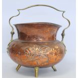 Arts & Crafts copper coal bucket of cauldron form with repousse floral motif on four brass stilt