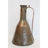 Large Eastern copper water jug, the hammered conical body with tapered shoulders, ringed cylindrical