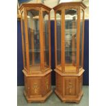 Pair of modern Chinese glazed display cabinets of octagonal form, the glazed door, enclosing two