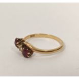 Early 20th century cross-over ring with diamond and two rubies (uncertificated) in gold, probably