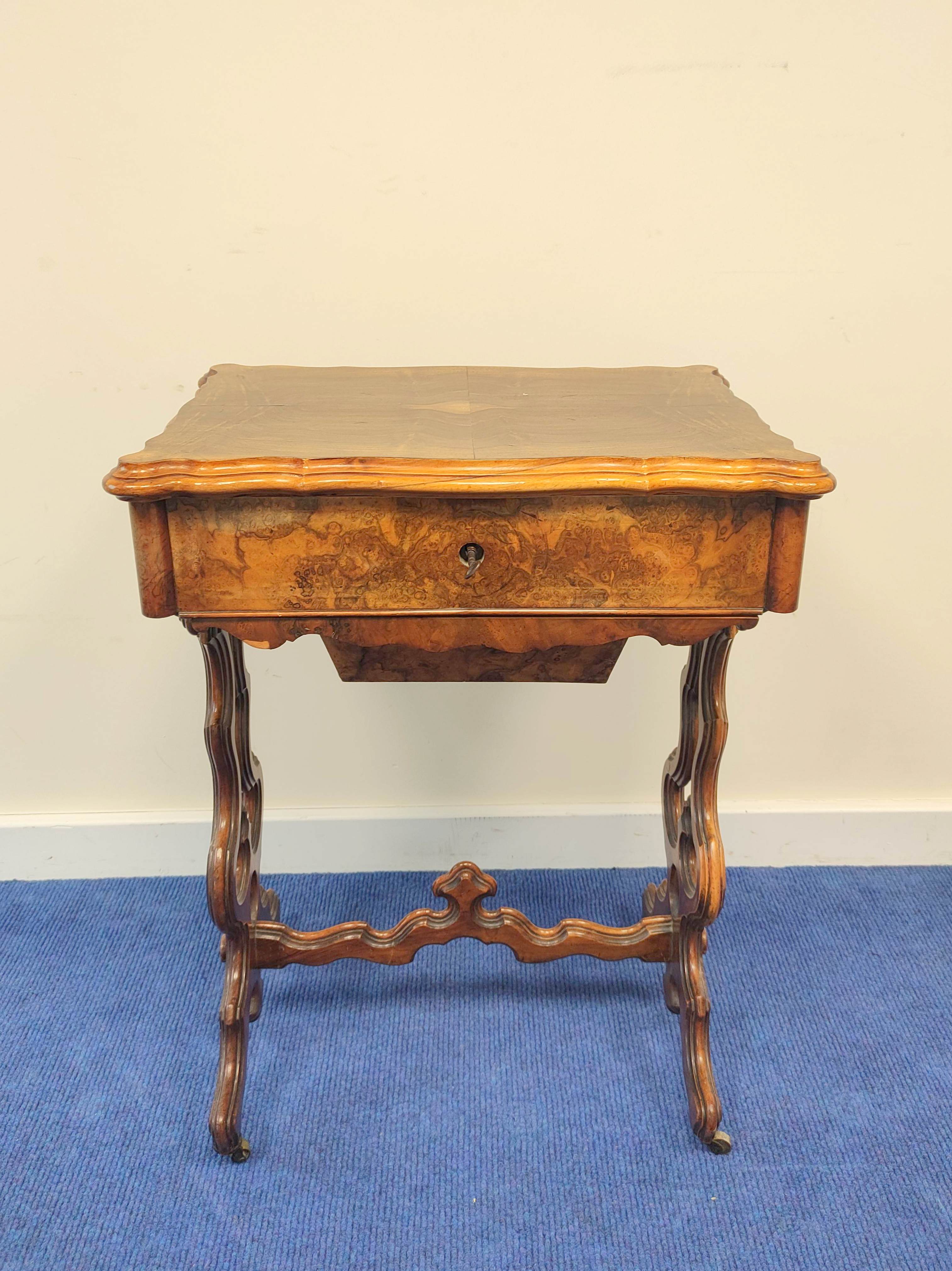 19th century burr walnut sewing table with hinged serpentine top enclosing a maple interior with a