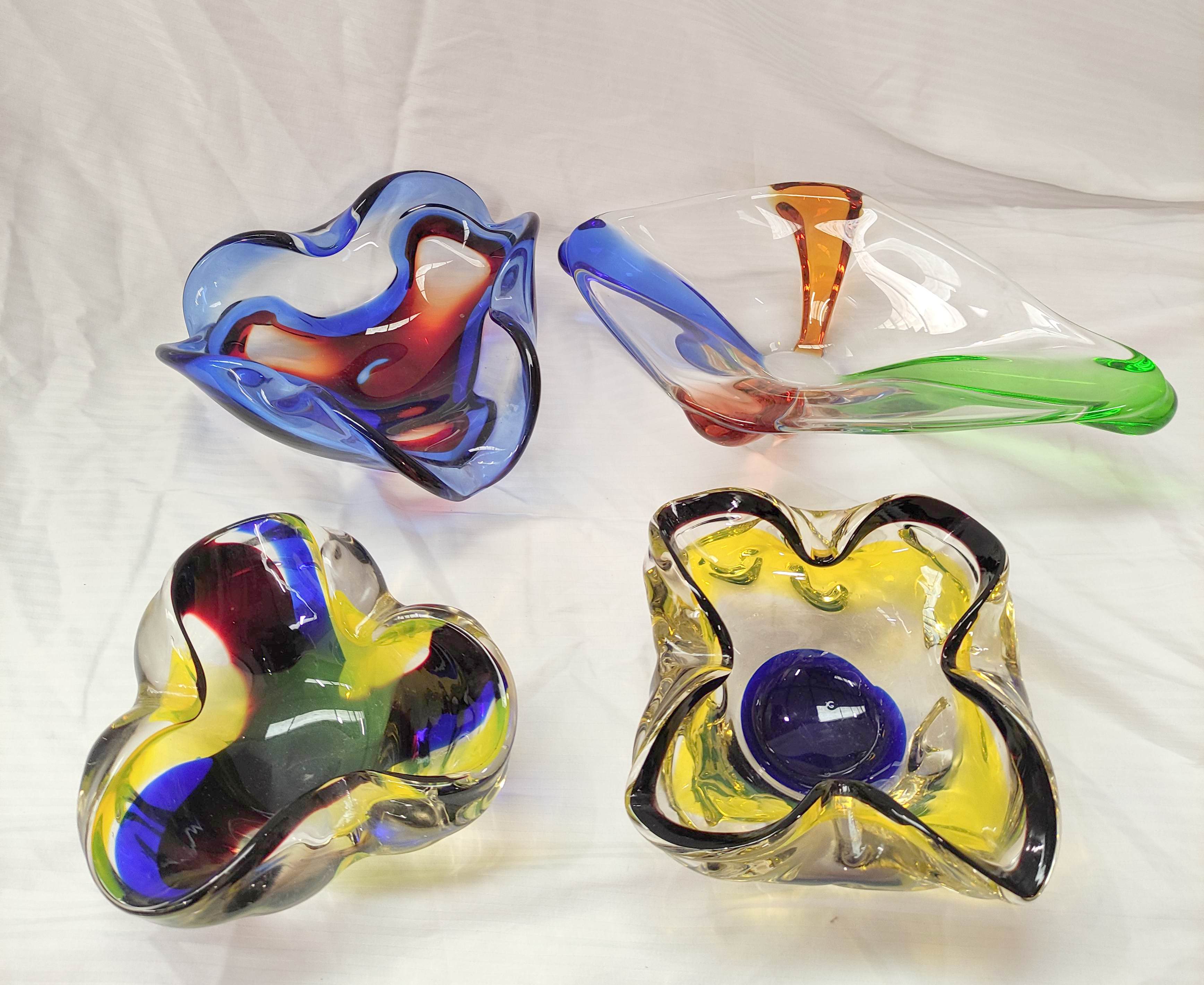 Four mid 20th century Continental art glass dishes or ashtrays, the largest 33cm wide.  (4).