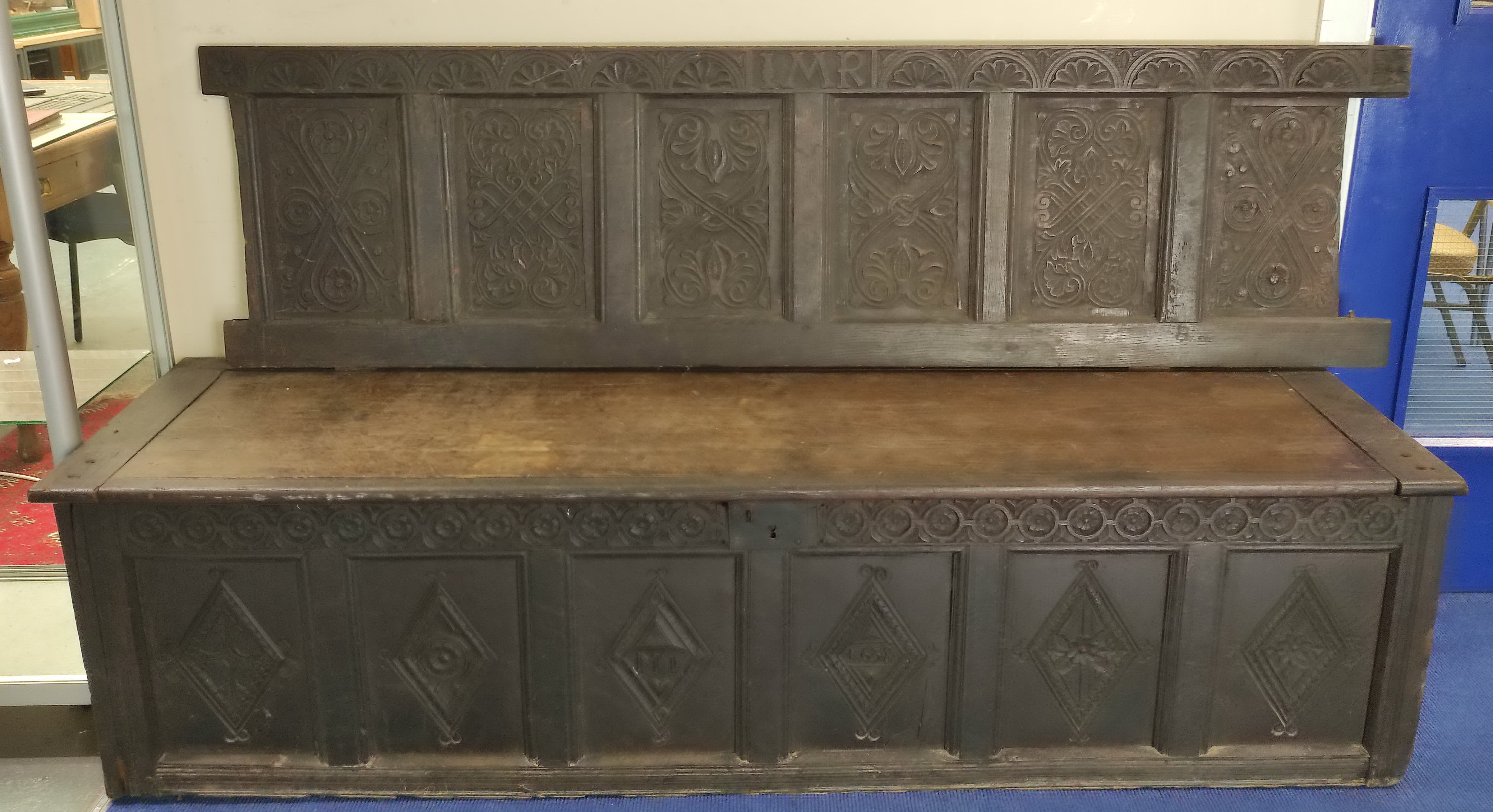 Charles I period carved oak hall bench, inscribed IMR and carved with floral panels and swags to the