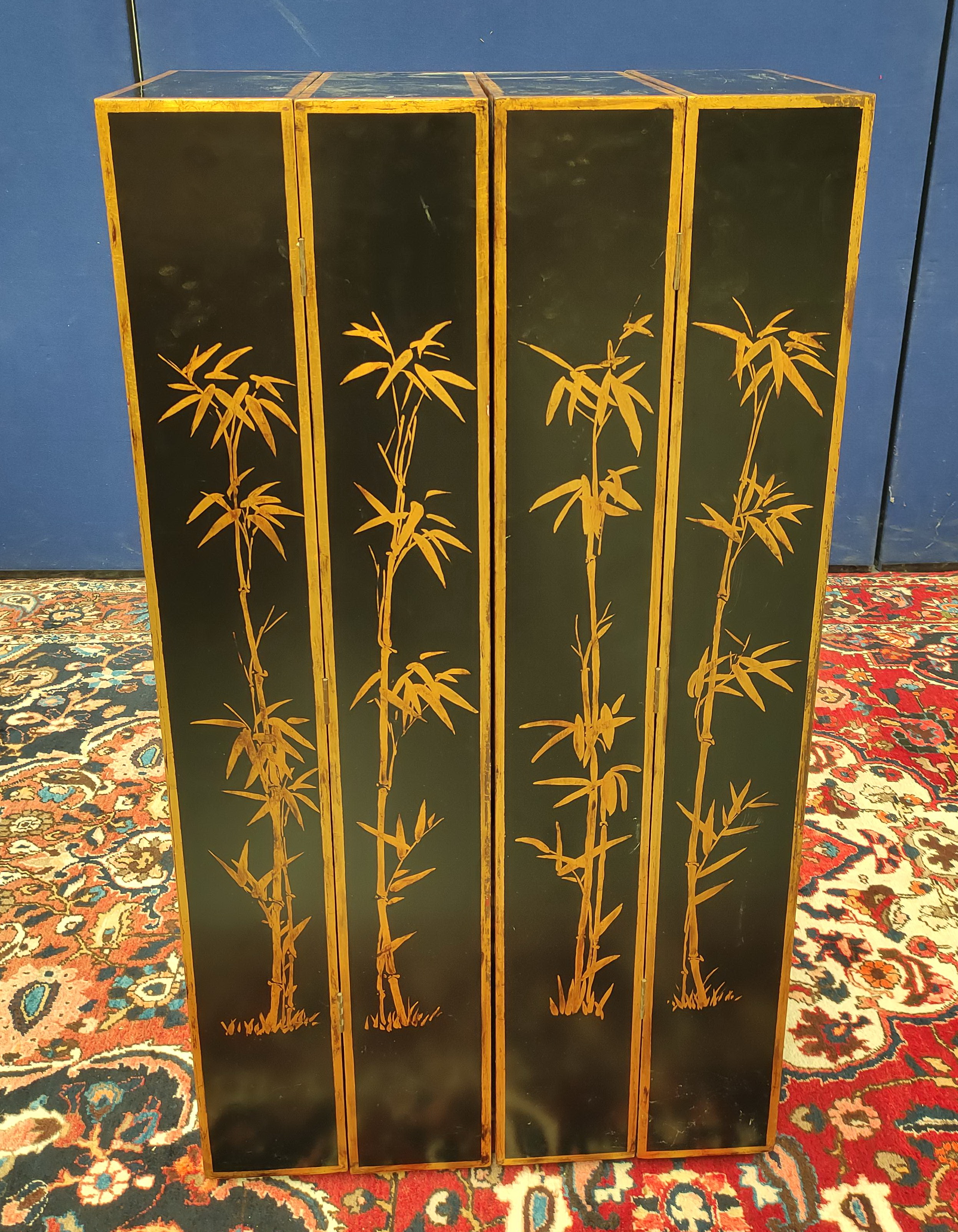 Chinese black lacquer and gilt screen divider in four sections with open shelving decorated with