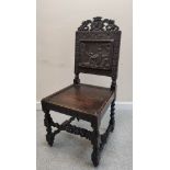 Jacobean revival carved oak hall chair, with a carved leaf and scroll surmount, above carved panel