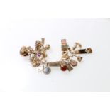 9ct gold charm bracelet with thirty two dependant charms most stamped for 9ct gold, 98.8 grams