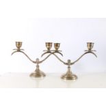 Pair of white metal twin branch candelabra, on shaped round bases, 456g gross, possibly stamped '