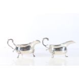 Two sterling silver sauceboats, with wavy edged rims, on paw supports, one Haselar Brothers,