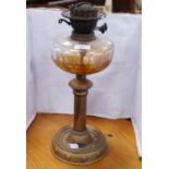 Brass-mounted oil lamp with amber-coloured glass reservoir.