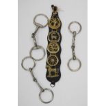 Set of horse brasses decorated with horses, stags and eagles, and three metal horse bits.