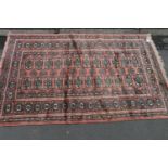 Turkish Bokhara rug on pink ground, 155cm x 100cm.