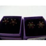 Two pairs of silver and garnet cluster earrings.