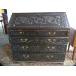 Jacobean Revival carved oak bureau.