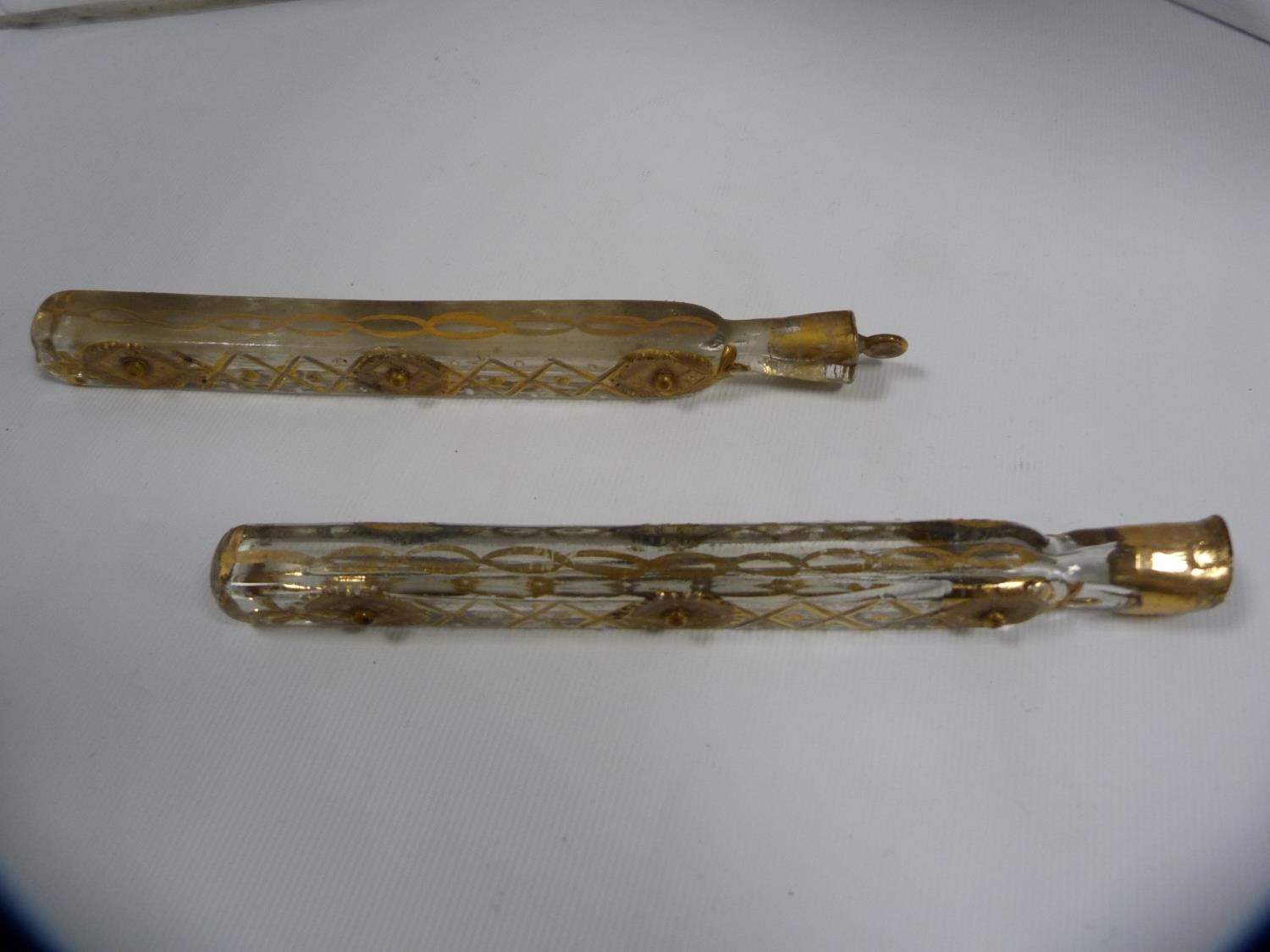 Two Georgian gilt-tooled and glass scent bottles, one with stopper and one without.