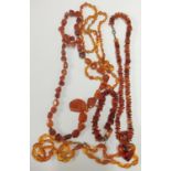 Group of amber-coloured jewellery to include four necklaces and a bracelet.