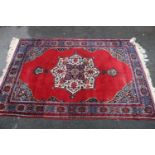 Belouch rug on red ground, 180cm x 116cm.