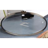 White metal-mounted oval wall mirror.