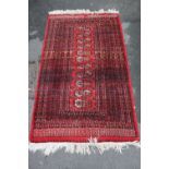 Turkoman hand-knotted rug on red ground, 164cm x 96cm.