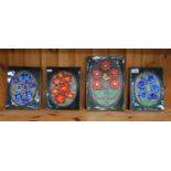 Four floral decorated pottery tiles.  (4)