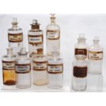 Collection of ten antique glass chemist's jars of medium size, named in black lettering on red,