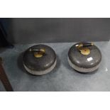 Pair of curling stones, each with a brass and wood grip.  (2)