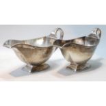 Pair of silver sauce boats of Art Deco angular style, with reeded handles, by Adie Brothers,