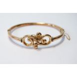 Gold hinged bangle with beaded scrolls, '9ct', 7.6g, cased.