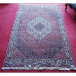 Bidjar rug decorated with graduated geometric centre on a cream and red ground, 178cm x 113cm.