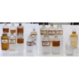 Collection of antique glass chemist's jars of large size, most named in black lettering on white,