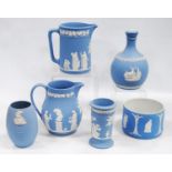 Six pieces of Wedgwood blue Jasper ware comprising two jugs, two spill vases and a small planter,