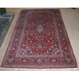 Persian Keshan rug decorated with all over floral swags on a red ground, 224cm x 136.5cm.