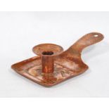 Arts & Crafts Newlyn hammered copper chamber stick with repoussé fish decoration, stamped '