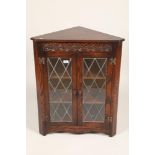 Carved oak two door corner cabinet