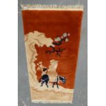 Chinese rug with figures and ass/donkey, within blossom trees and landscape decoration, on red,
