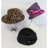 Three Philip Treacy of London hats: faux leopard skin with feathers; dark plum straw with pink