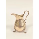 Silver cream jug of Georgian style, pear shaped on lion mask and paw feet, London 1906. 100g, 3oz.