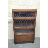 Oak stacking bookcase by Globe Wernicke, the four sections with leaded glass doors, raised on