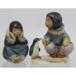 Two Lladro Gres figures of Inuit children, one crouching beside an ice fishing hole with penguin,