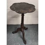 Edwardian mahogany wine table, the lobed circular top on ring and leaf carved turned column with