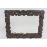 Late 19th or early 20th century Chinese carved hardwood wall mirror, the frame in the form of two