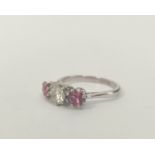 Three stone ring with diamond brilliant approx .6ct, flanked by two pink tourmalines in white