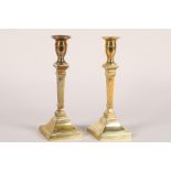 Pair of brass square tapering candlesticks; raised on stepped square bases; 25cm high
