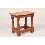 Robert Mouseman of Kilburn oak stool, the adzed saddle seat on octagonal chamfered legs united by
