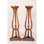 Pair mahogany plant stands, carved circular tops raised on three carved scroll supports, united by