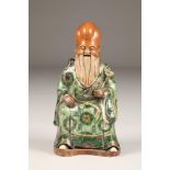 19th Century Chinese porcelain seated figure of Shou Lao, God of Longevity, in a green robe