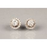 Pair of ladies diamond stud earrings, with diamond surrounds, on unmarked white metal, each