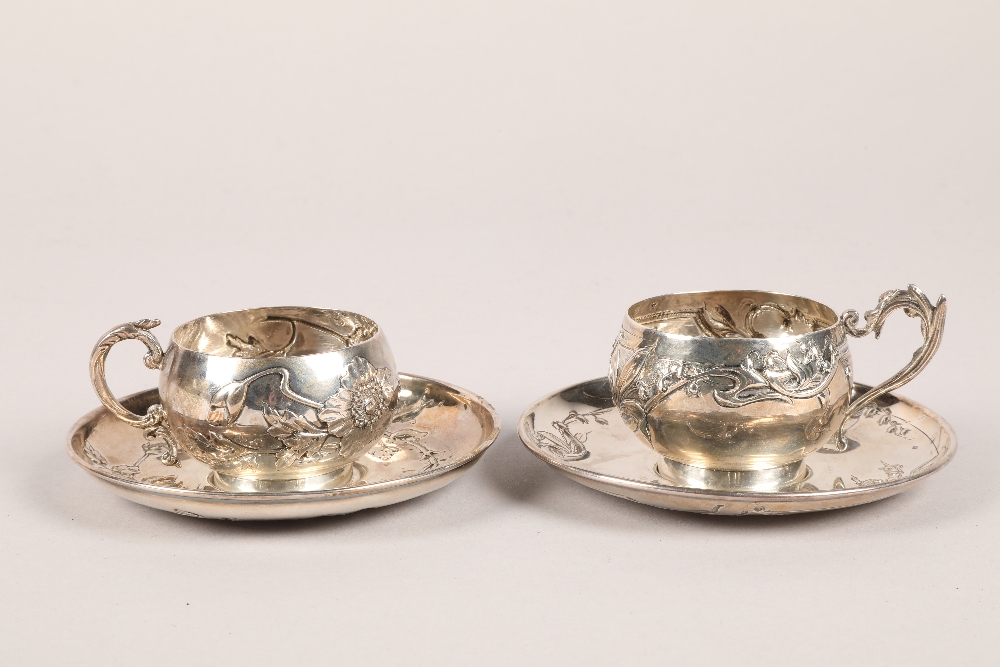 Pair Continental art noveau silver cups and saucers, embossed floral decoration, saucer diameter