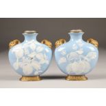 Pair Royal Worcester moon flask vases, decorated with flowering plants, raised on gilt