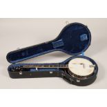 A Saga 5 string Banjo, with Saga in mother of pearl on headstock, overall length 97 cm in lined